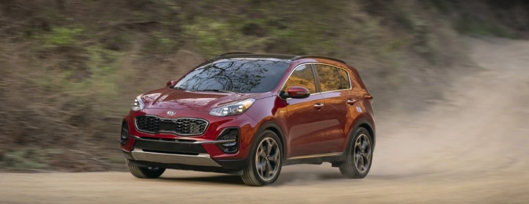 Sideview of a 2022 Kia Sportage cruising down a dusty road. What are the engine specifications?