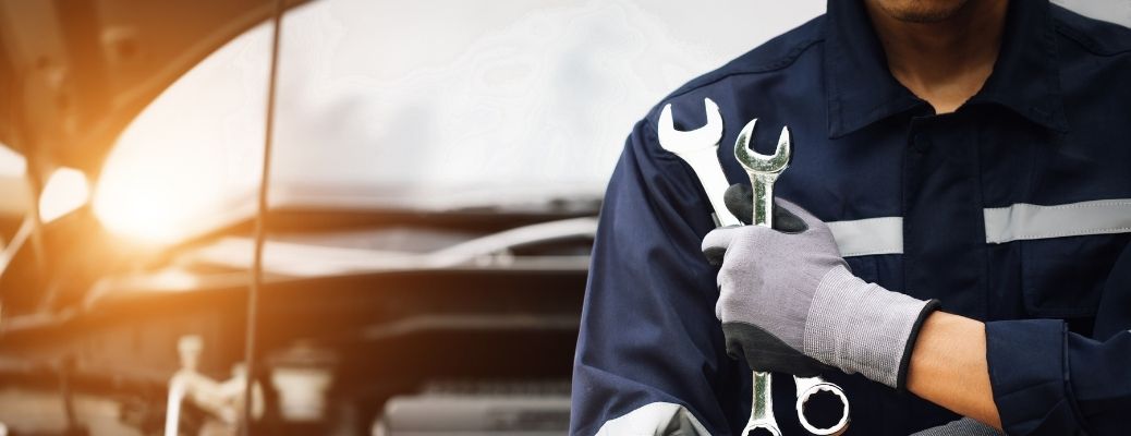 Car mechanic holding a pair of wrenches