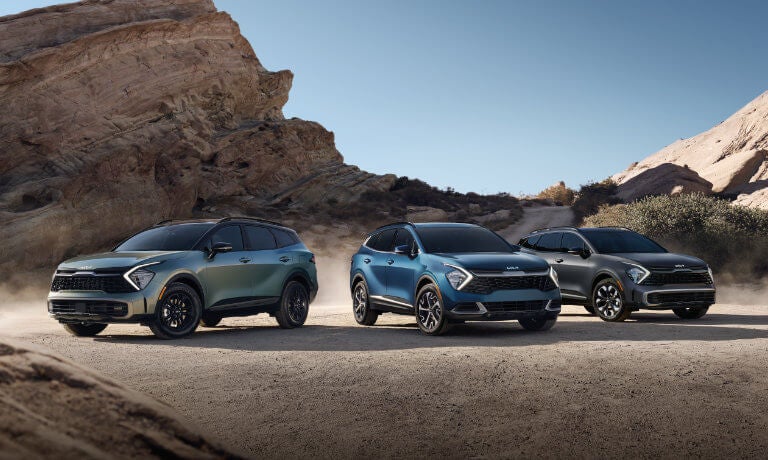 Three 2024 Kia Sportages parked in the desert